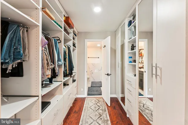 a view of walk in closet with clothes and shoes