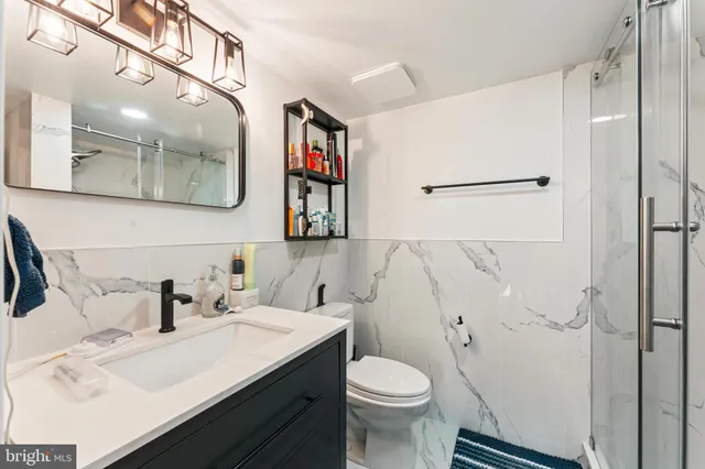 a bathroom with a sink a toilet and shower
