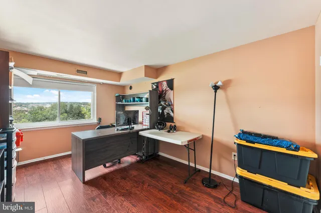 a view of a workspace with furniture and a window