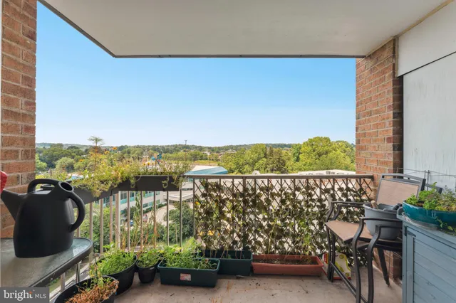 a view of a balcony with chairs and a potted plant