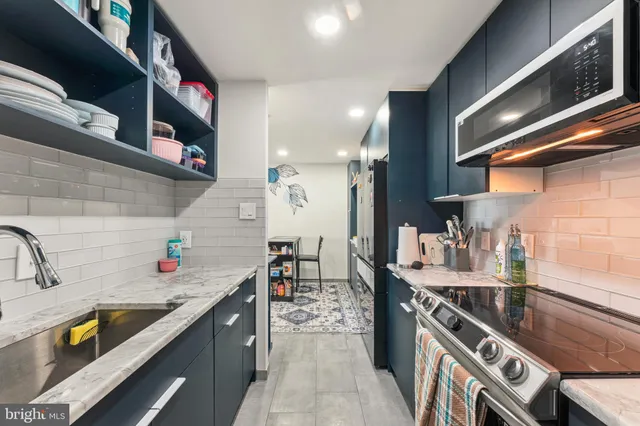 a kitchen with stainless steel appliances granite countertop a sink stove and cabinets
