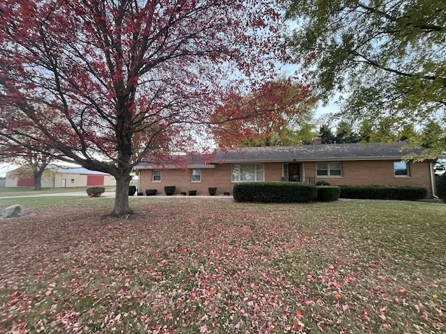 a front view of a house with a yard and trees