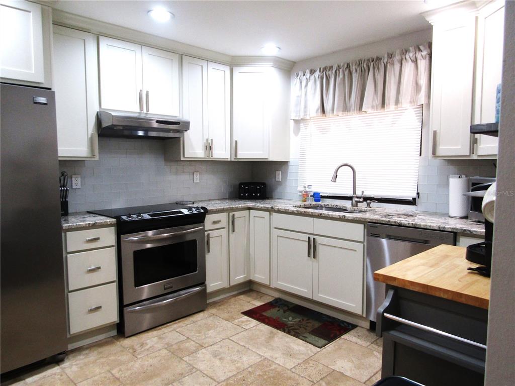 5056 Marsh Field Road, Unit 7 Sarasota, FL 34235 - Photo 11 of 31 a kitchen with stainless steel appliances a sink stove and cabinets