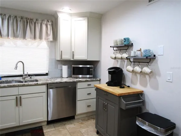 a kitchen with cabinets appliances and a sink
