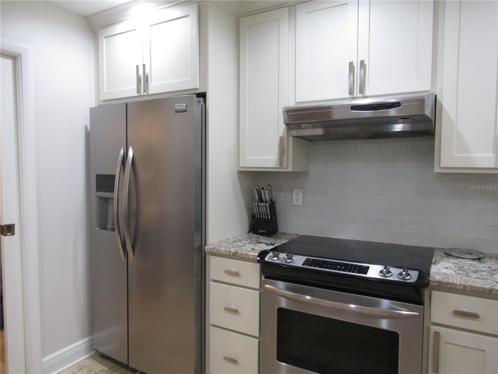 5056 Marsh Field Road, Unit 7 Sarasota, FL 34235 - Photo 13 of 31 a kitchen with stainless steel appliances granite countertop a refrigerator and a stove