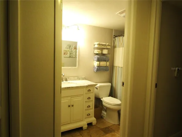 a bathroom with a granite countertop sink a toilet and shower