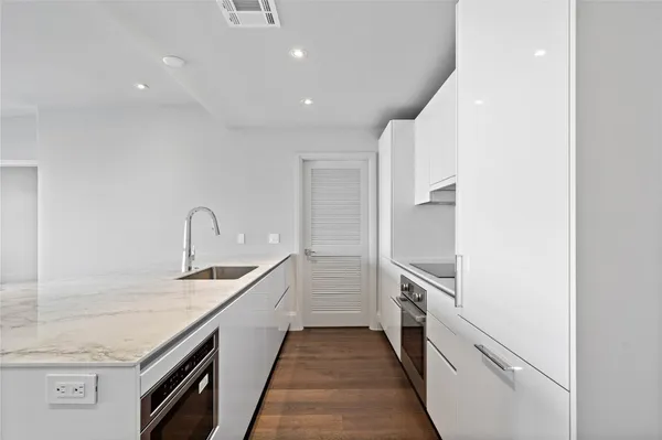 a kitchen with granite countertop white cabinets and stainless steel appliances