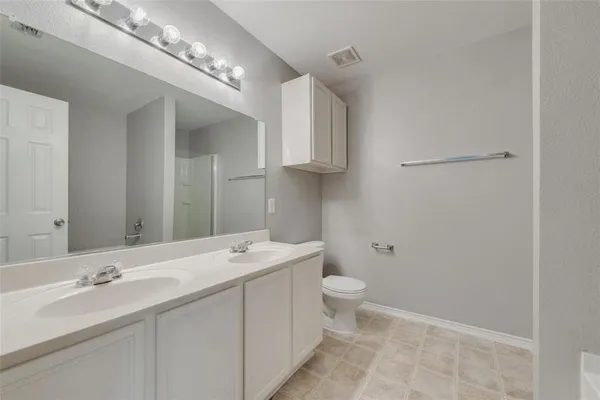 a bathroom with a double vanity sink and a mirror