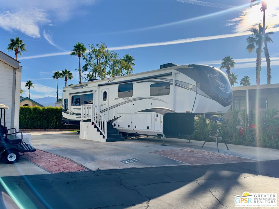 69801 Ramon Road, Unit 201 Cathedral City, CA 92234 - Photo 2 of 7 a white building with a large window and potted plants