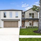 a view of a white house with a large tree