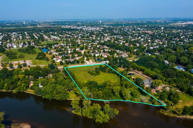 an aerial view of residential houses with outdoor space and trees