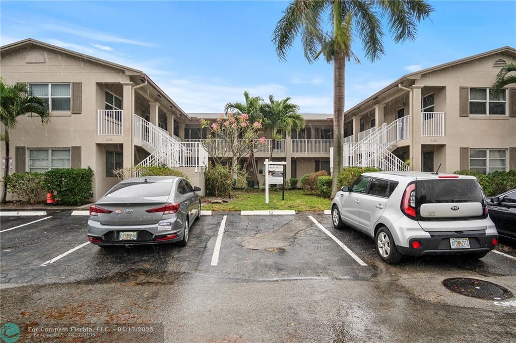 2130 Northeast 42nd Court, Unit 8 Lighthouse Point, FL 33064 - Photo 1 of 19 a car parked in front of a white house