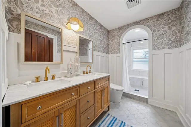 a spacious bathroom with a granite countertop toilet sink and mirror