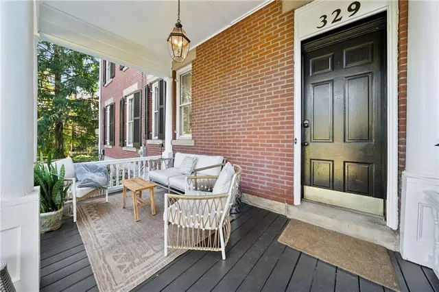 a view of a patio with couches chairs potted plants and wooden floor