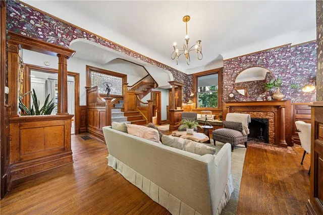 a living room with furniture a fireplace and a chandelier