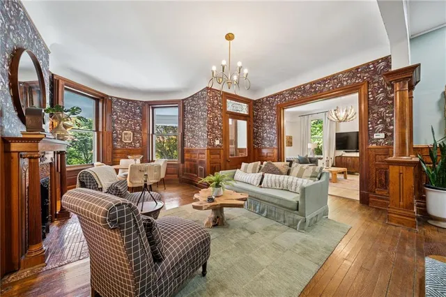 a living room with furniture a large window and wooden floor