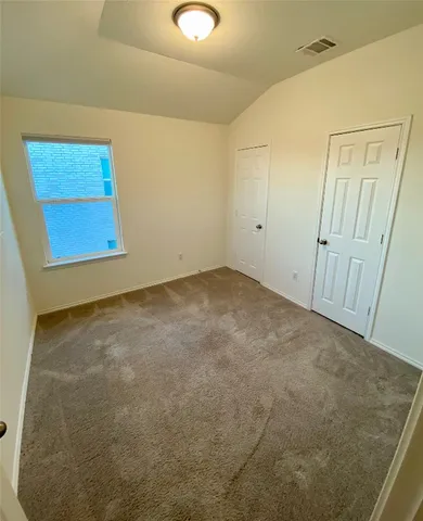 an empty room with a ceiling fan and a window