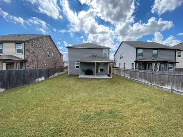 a view of house with swimming pool and a yard