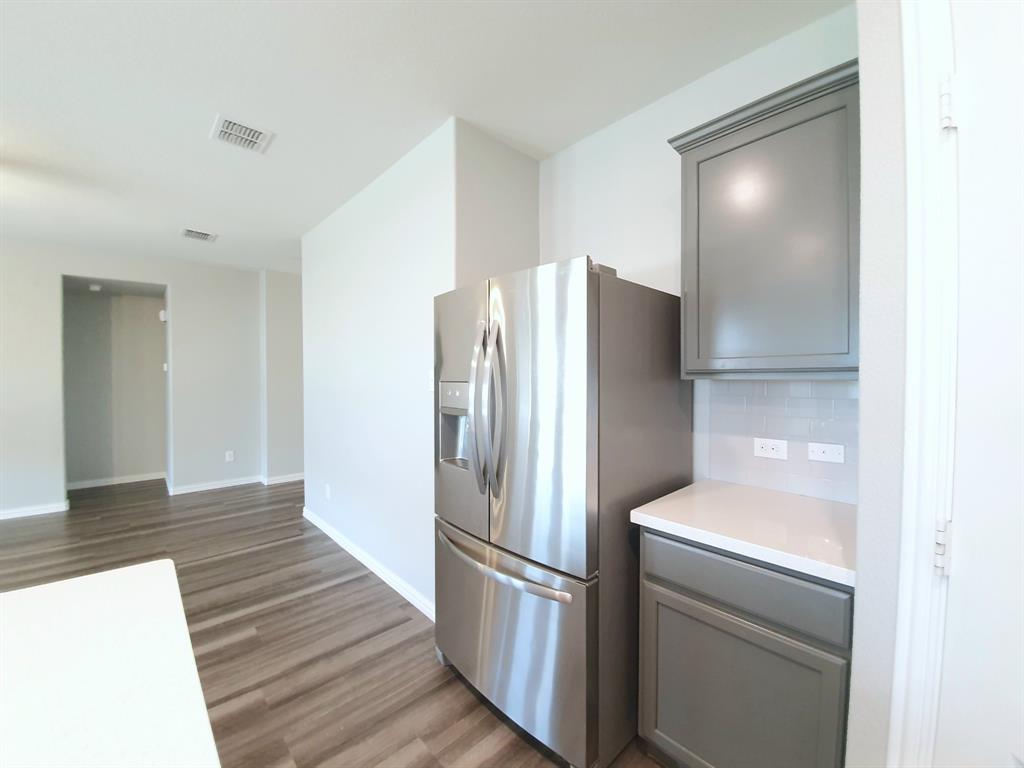 822 Spruce Lane Princeton, TX 75407 - Photo 12 of 35 a kitchen with a refrigerator and a sink