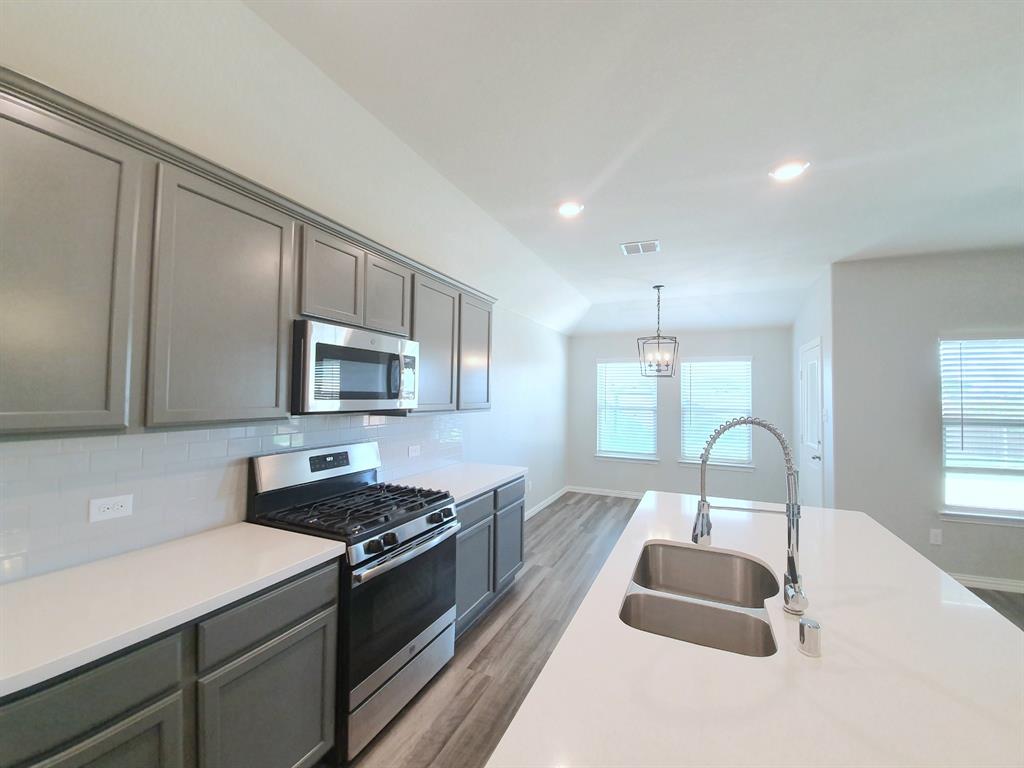 822 Spruce Lane Princeton, TX 75407 - Photo 13 of 35 a kitchen with stainless steel appliances granite countertop a sink stove and cabinets