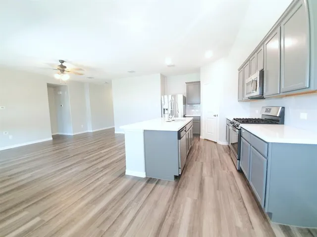 a large kitchen with kitchen island a sink dishwasher a stove and a wooden cabinets