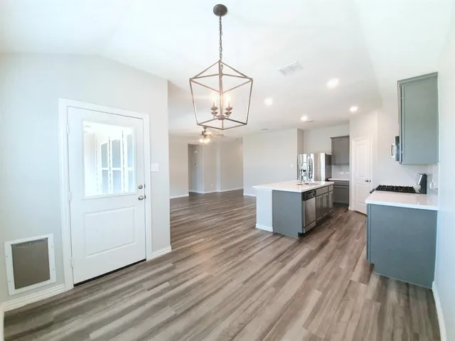 a view of a kitchen with wooden floor and a sink