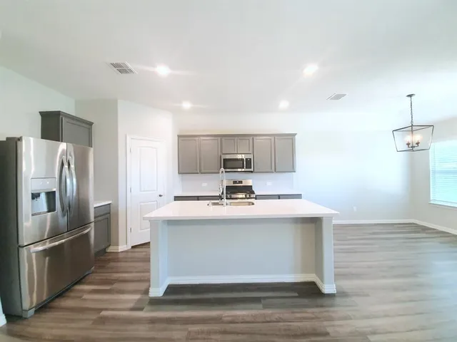 a view living room with stainless steel appliances kitchen island a sink a stove and a refrigerator