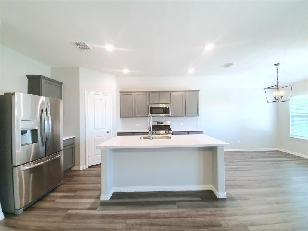 822 Spruce Lane Princeton, TX 75407 - Photo 18 of 35 a view living room with stainless steel appliances kitchen island a sink a stove and a refrigerator