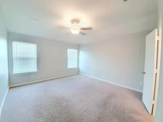 an empty room with windows and closet