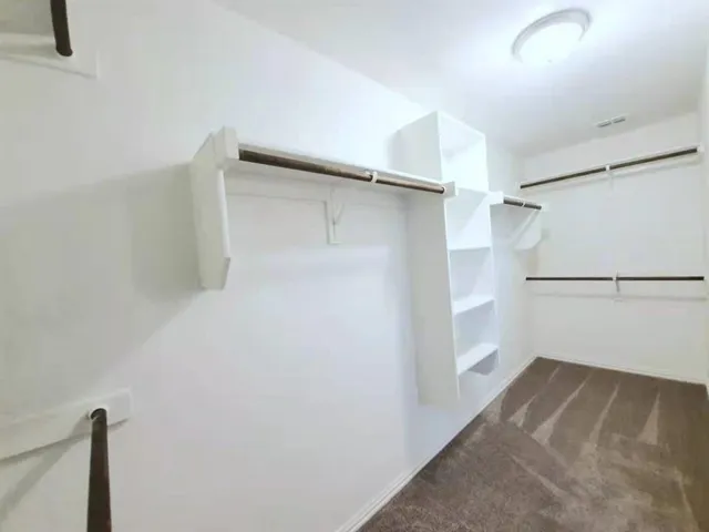 a view of walk in closet with empty racks