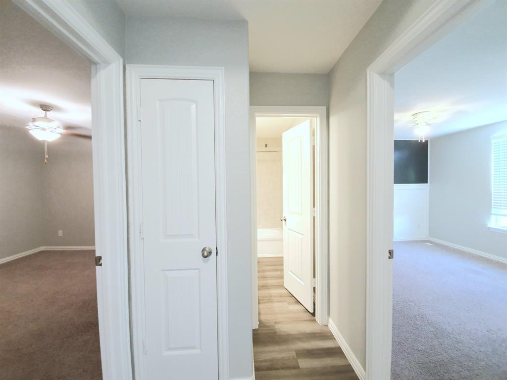 822 Spruce Lane Princeton, TX 75407 - Photo 31 of 35 a view of a hallway with a wooden door