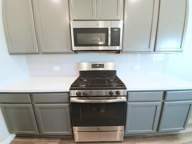 a stove top oven sitting inside of a kitchen