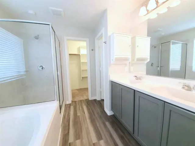 a spacious bathroom with a double vanity sink and a large mirror