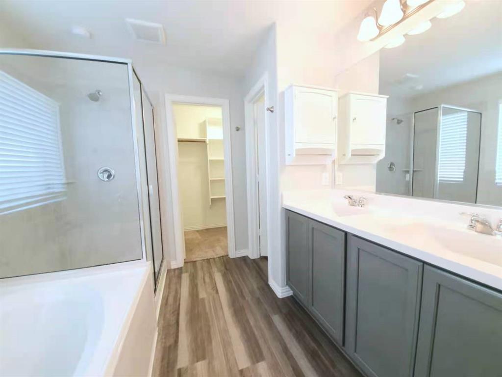 822 Spruce Lane Princeton, TX 75407 - Photo 9 of 35 a spacious bathroom with a double vanity sink and a large mirror