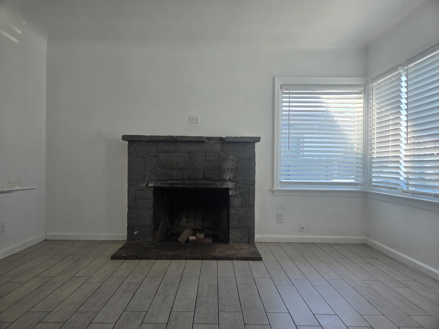 320 North Sanborn Road Salinas, CA 93905 - Photo 7 of 26 an empty room with wooden floor a fireplace and windows