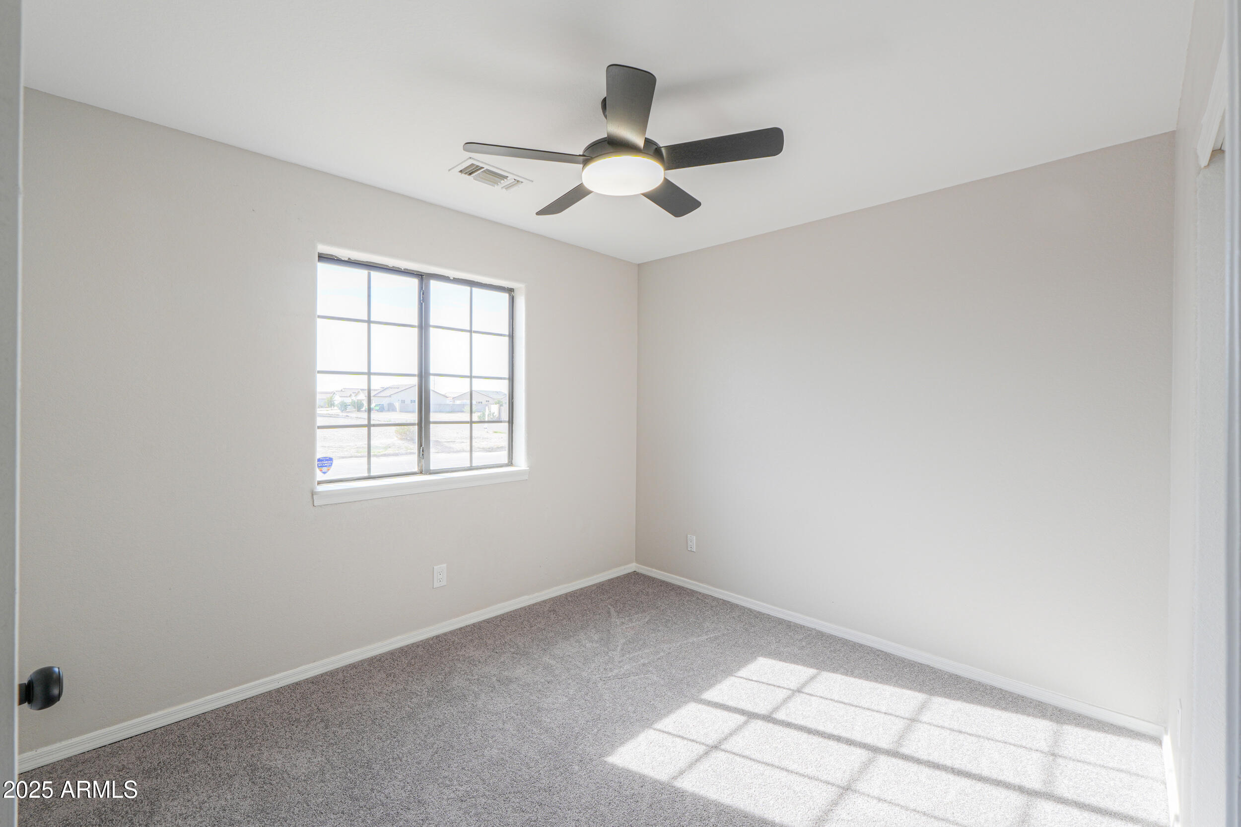 15741 Coral Road Arizona City, AZ 85123 - Photo 12 of 32 an empty room with windows and ceiling fan