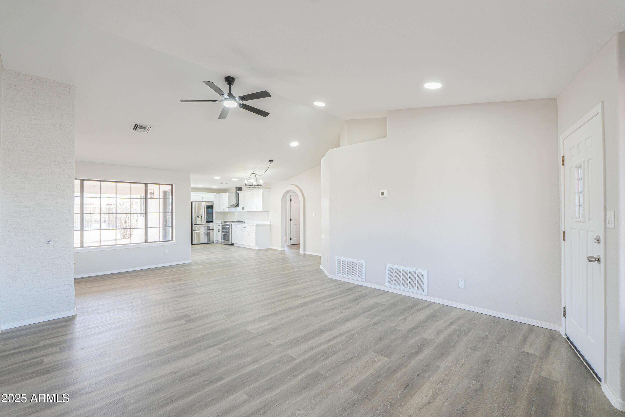 15741 Coral Road Arizona City, AZ 85123 - Photo 5 of 32 an empty room with wooden floor ceiling fan and windows