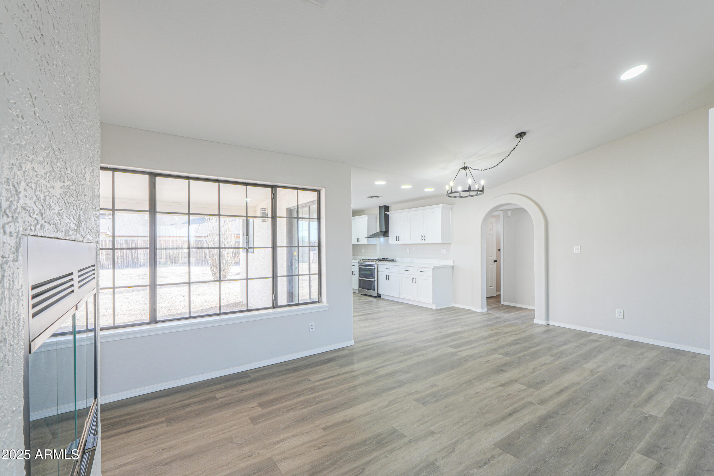 15741 Coral Road Arizona City, AZ 85123 - Photo 6 of 32 an empty room with wooden floor and windows
