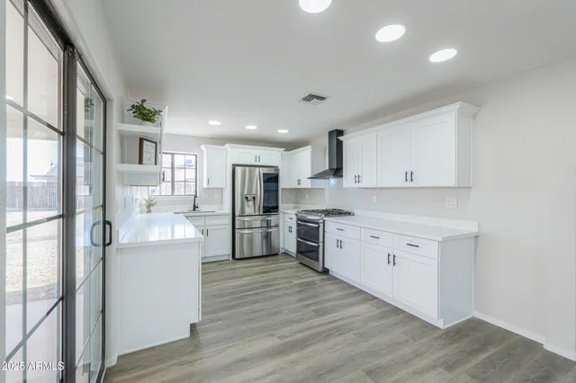 a kitchen with stainless steel appliances a refrigerator sink and cabinets