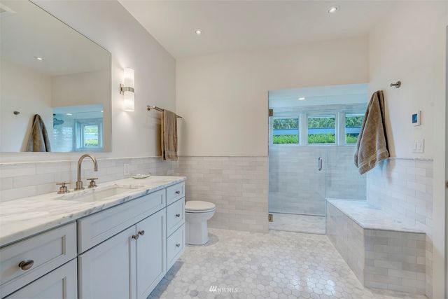 a bathroom with a sink a toilet and mirror
