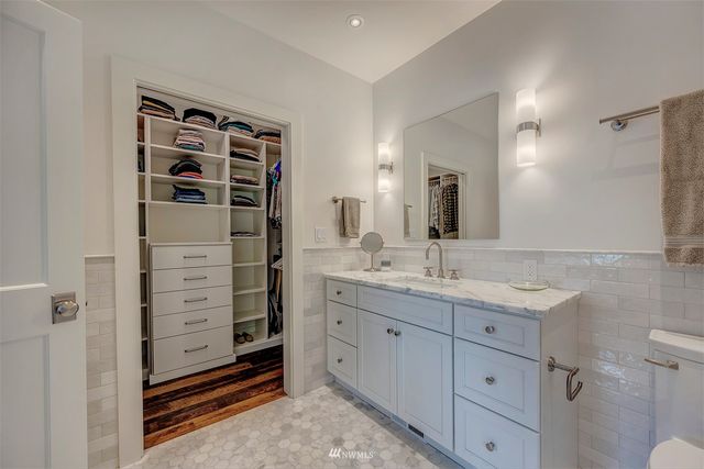 a bathroom with a granite countertop sink vanity mirror bathtub cabinet