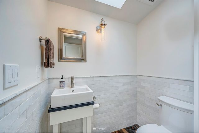 a bathroom with a sink a toilet and mirror