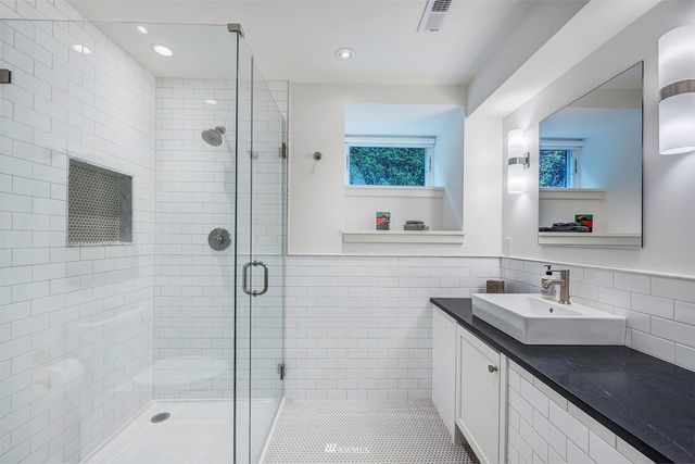 a bathroom with a shower sink and mirror