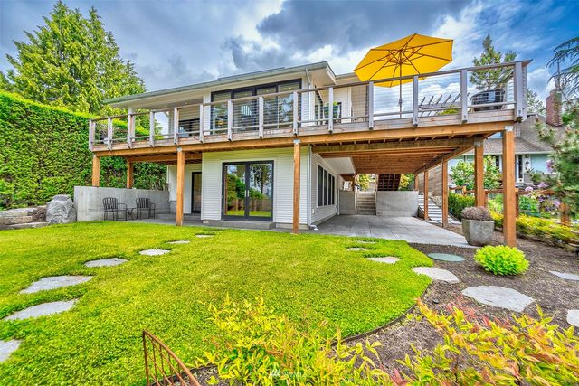 a view of a house with a swimming pool lawn chairs and a yard