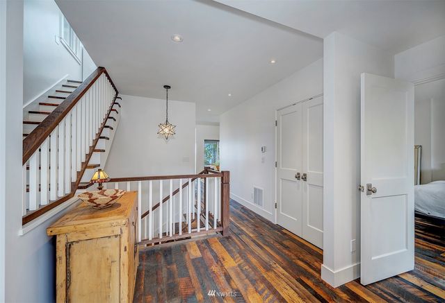 a view of a hallway with wooden floor and staircase