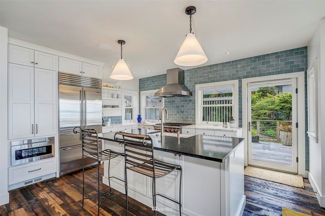 a kitchen with stainless steel appliances granite countertop a stove a sink and a wooden floors
