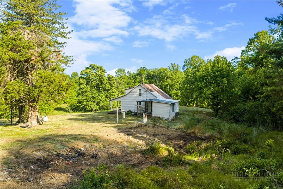 657 Lawrence Greene Road Deep Gap, NC 28618 - Photo 5 of 25 a house with green field in front of it