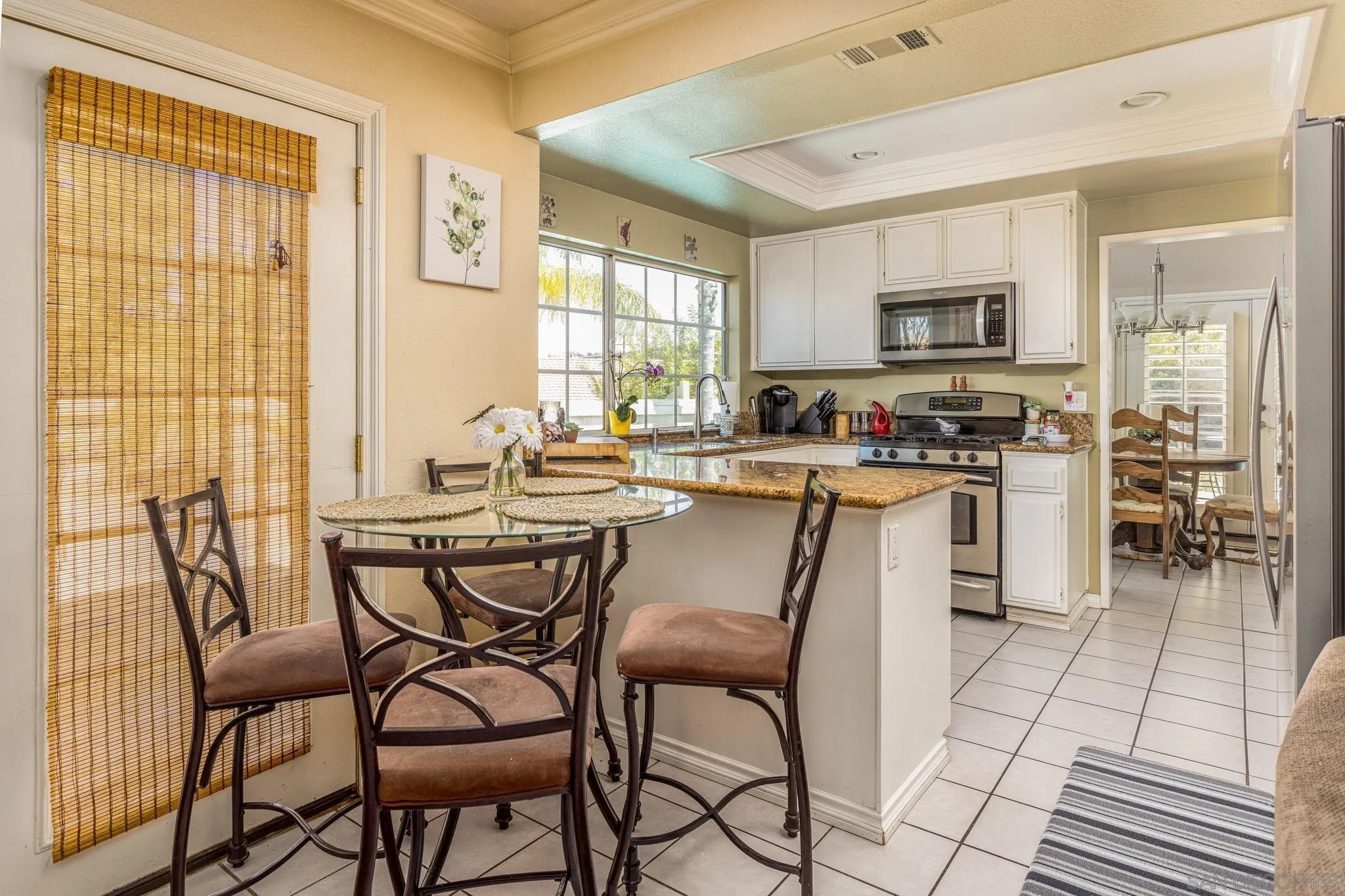 4648 Valley Glen Drive Corona, CA 92878 - Photo 12 of 42 a dining area with stainless steel appliances a table chairs and a refrigerator