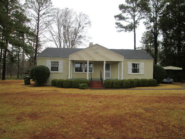6121 Forsyth Road Macon, GA 31210 - Photo 2 of 17 a front view of a house with yard patio and green space