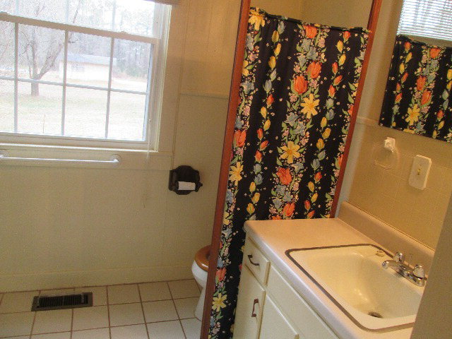 6121 Forsyth Road Macon, GA 31210 - Photo 14 of 17 a bathroom with a granite countertop sink and a mirror